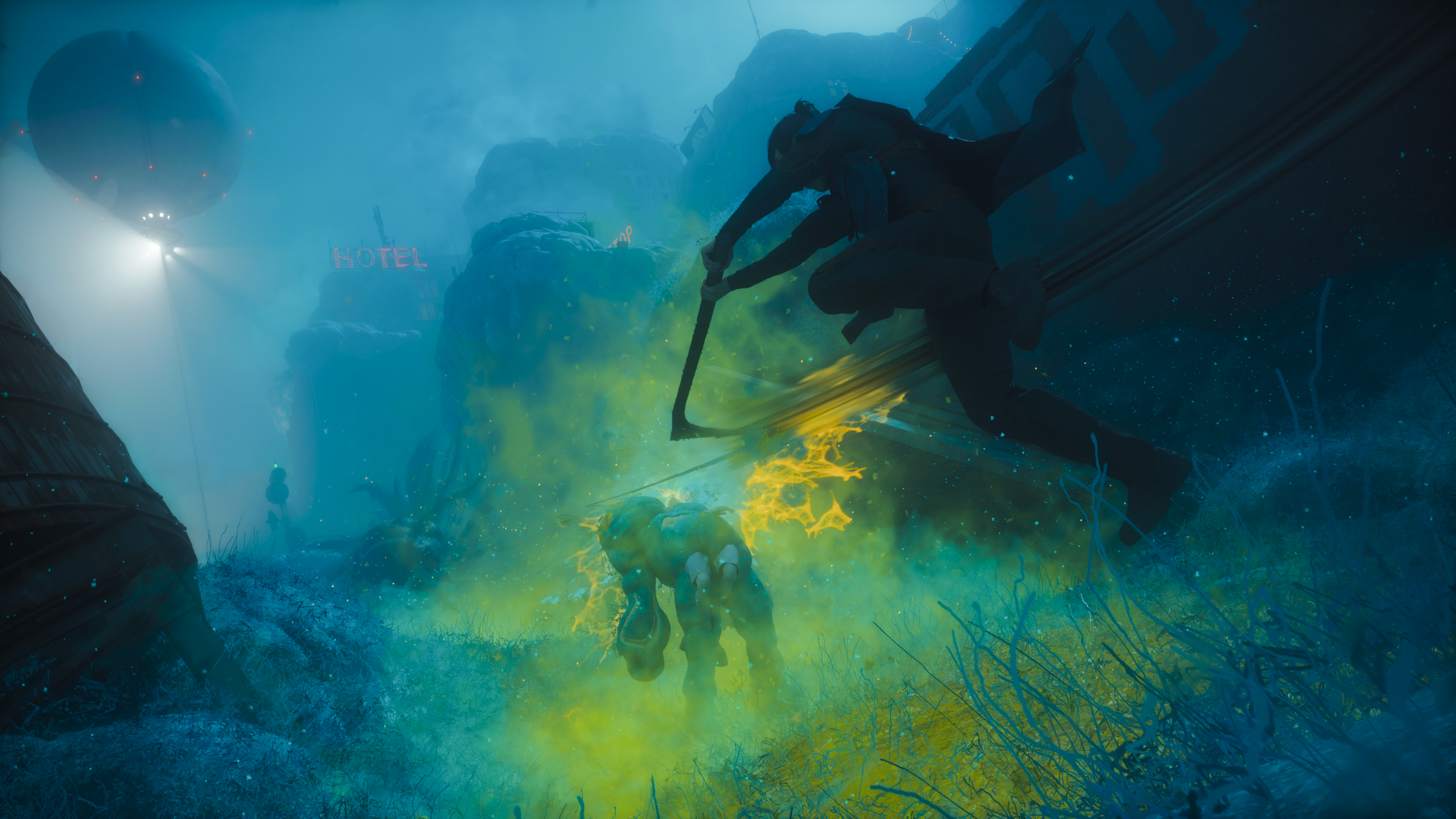 Yellow fire burning through blue fog, with the hotel sign reduced to a smear in the background.