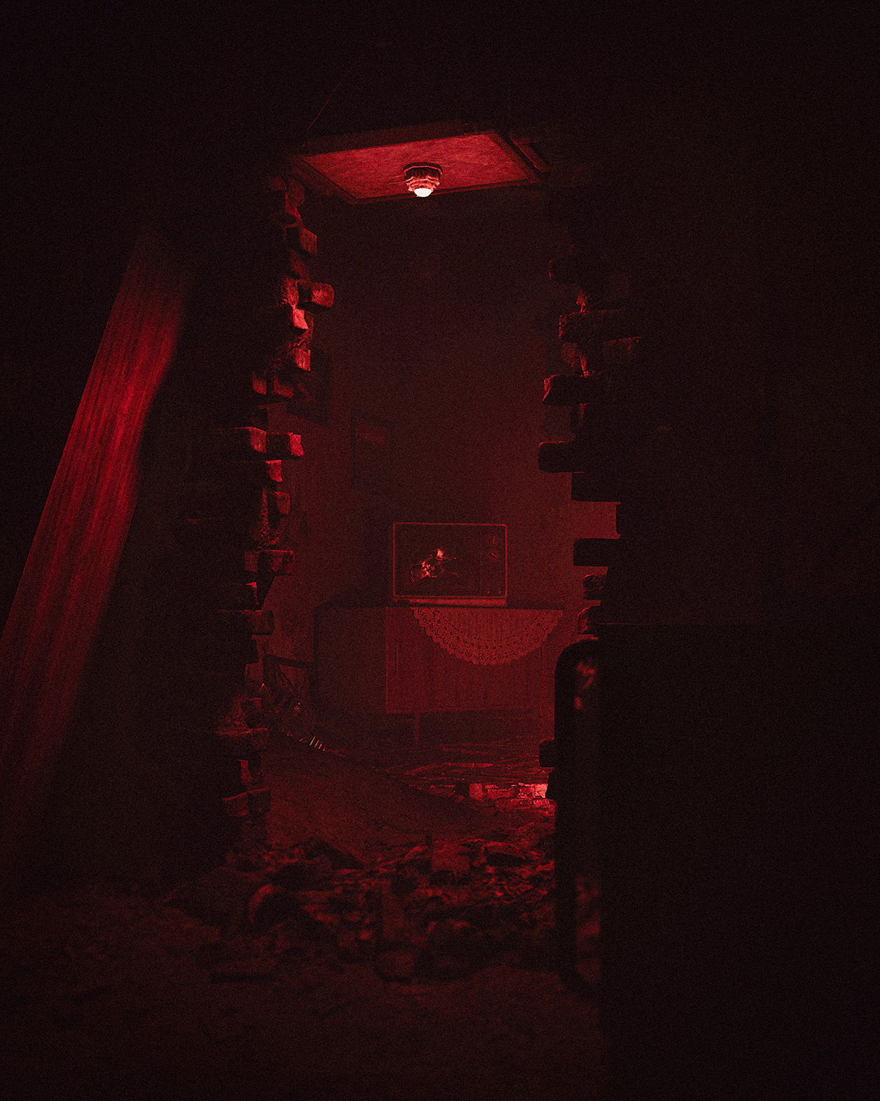 A room lit red through a hole in the wall, with a picture still hanging above the sideboard.